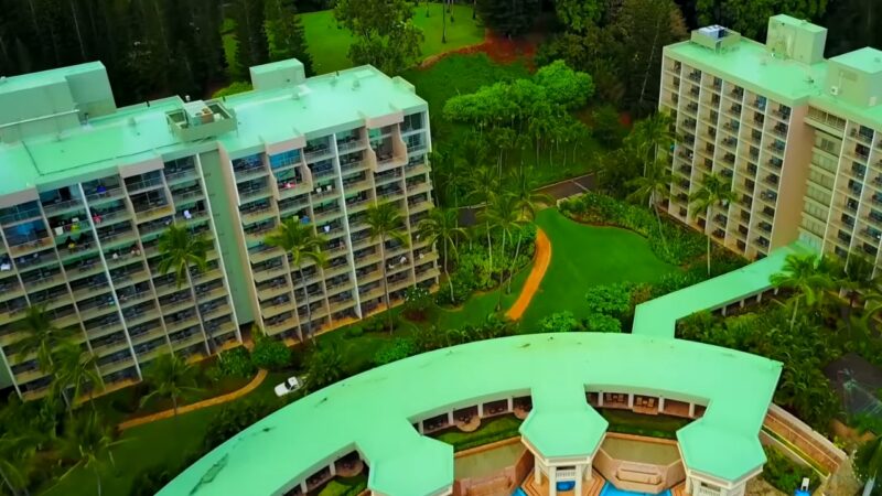 Aerial View of A Lush Hawaiian Resort with Multiple High-Rise Buildings Surrounded by Tropical Vegetation