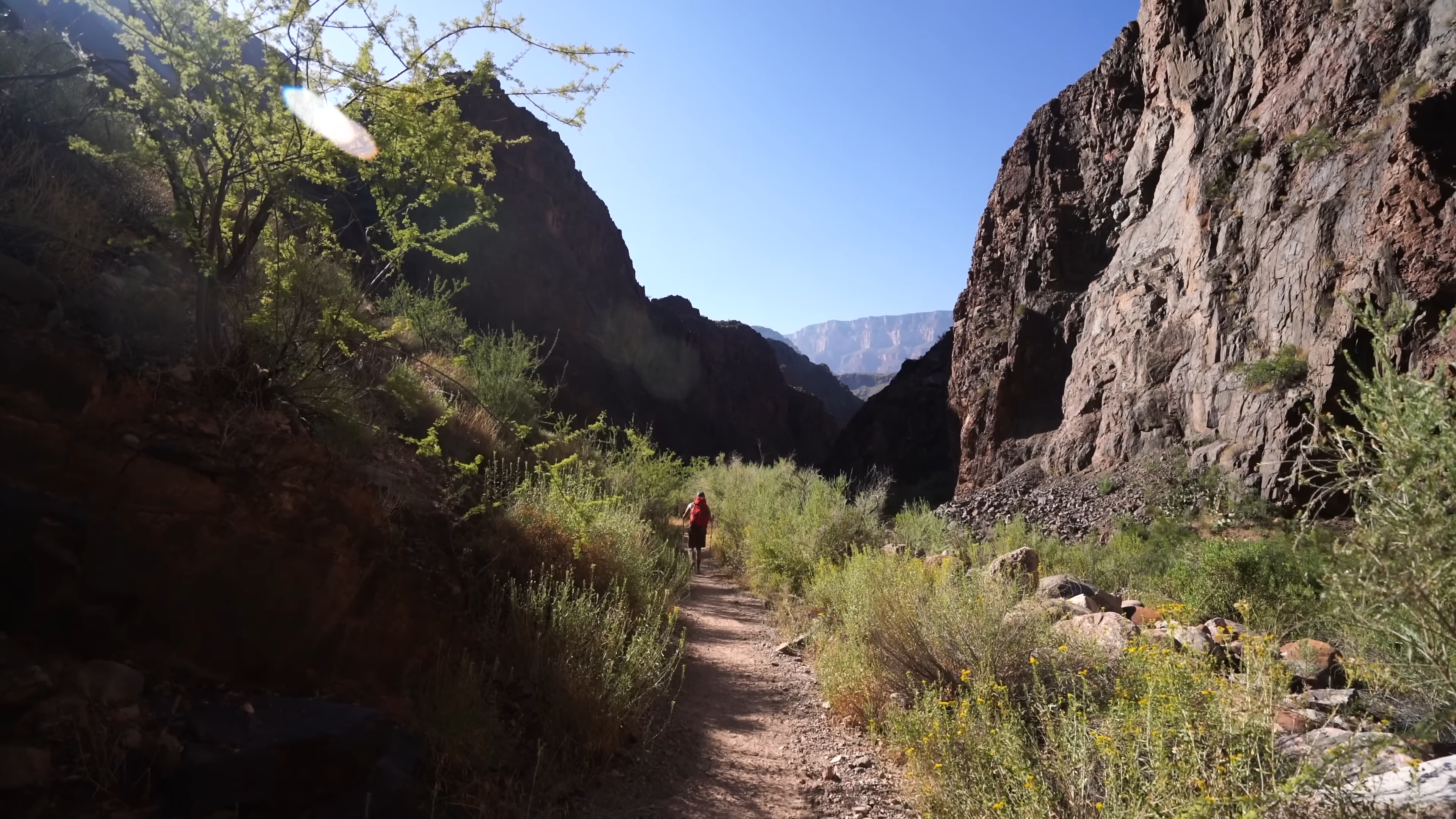 A Hiker Walking Along a Narrow Trail Between Towering Rock Formations in One of The Most Demanding Hikes in The US