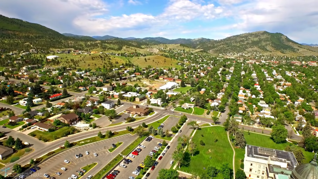 Aerial View of A Montana Town with Residential Areas, Green Spaces, and Surrounding Mountains