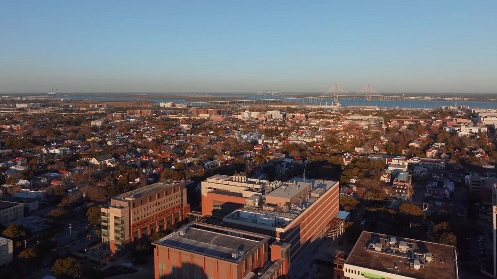 Aerial view of Charleston, West Virginia, with residential areas, downtown buildings, and a bridge crossing the river on a sunny day