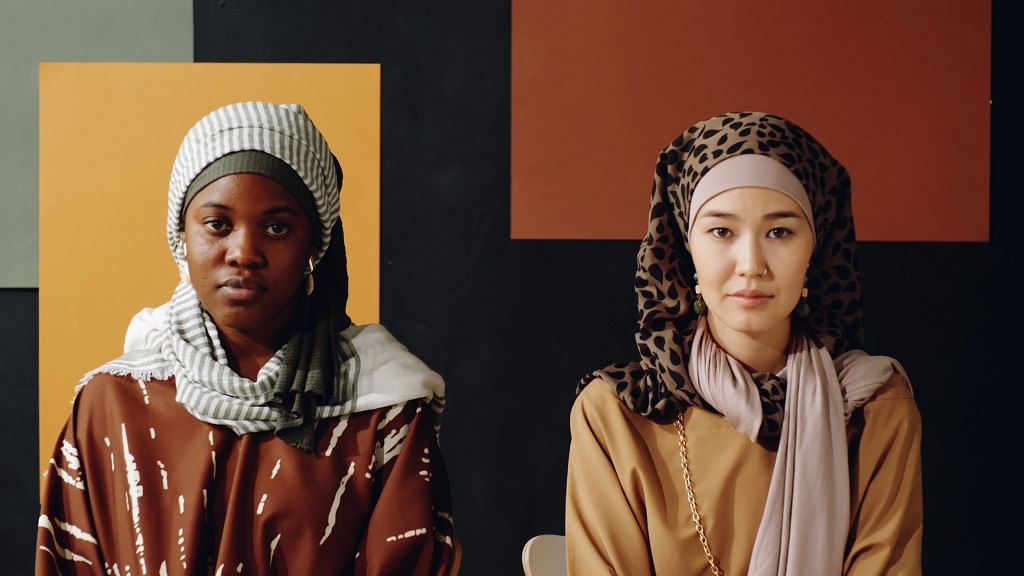 Two immigrant women wearing traditional clothing, symbolizing cultural diversity and challenges