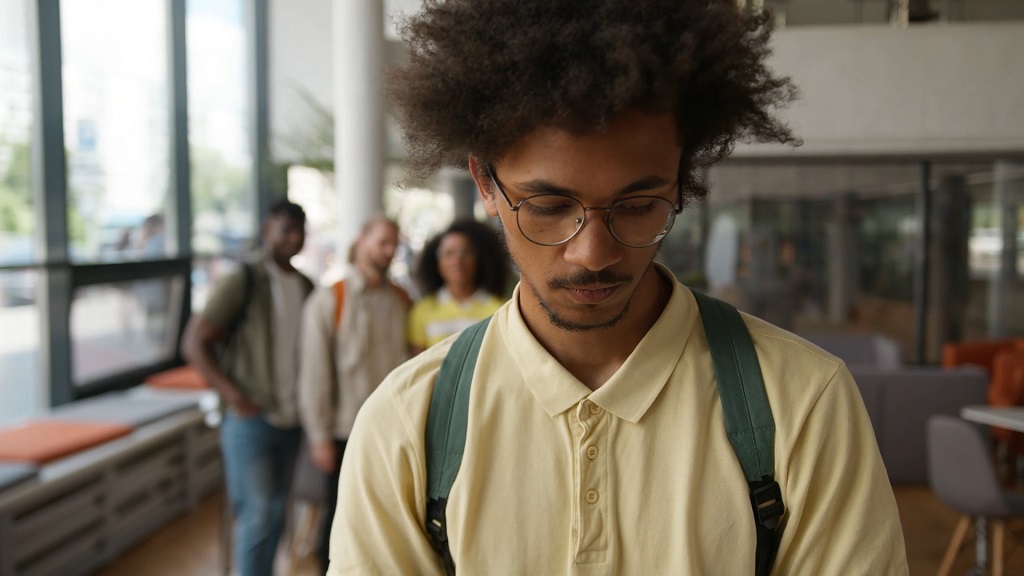 Immigrant student feeling isolated due to discrimination in a public space.