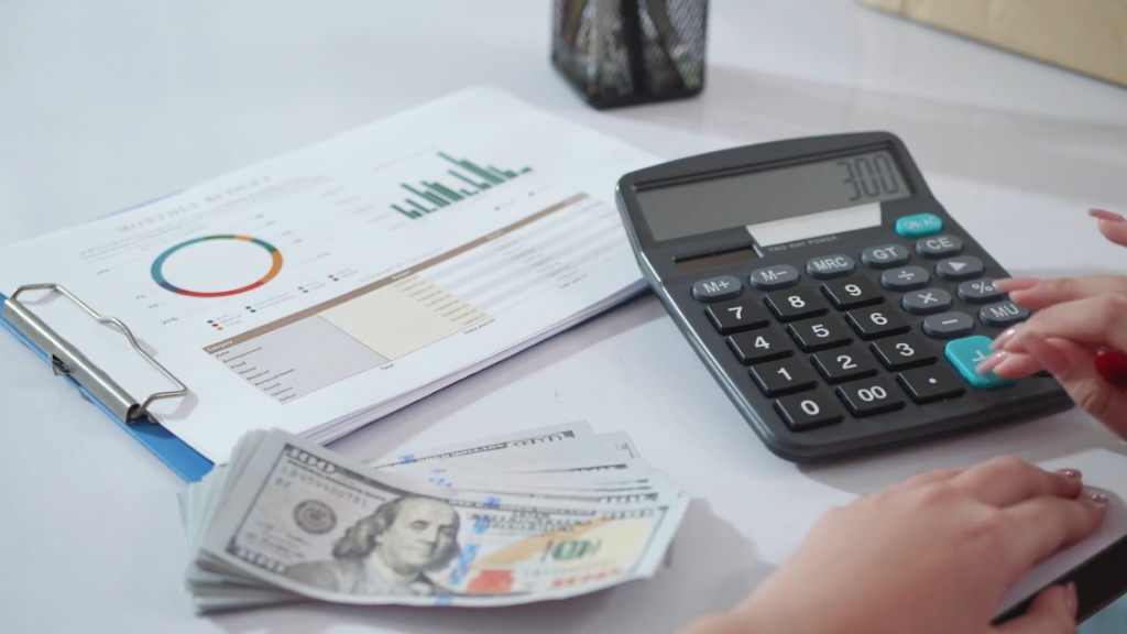 Cash, charts, and a calculator show average monthly utility costs in the United States