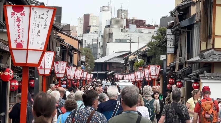 Crowd of people walking through the streets of Kyoto