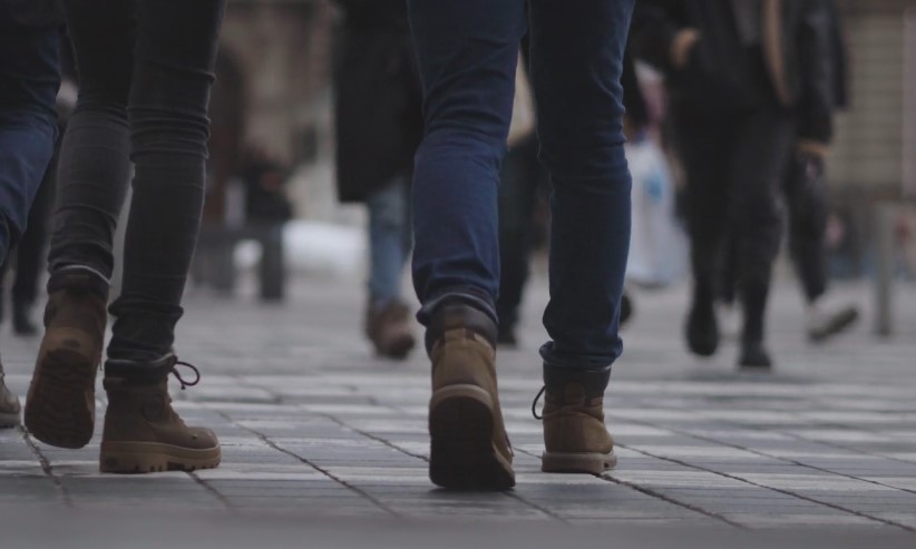 People walking on a street, wearing various styles of shoes