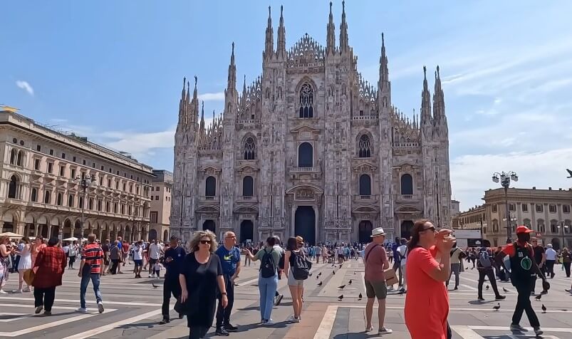 A sunny day in Milan's Piazza del Duomo, with crowds milling before the magnificent Gothic cathedral