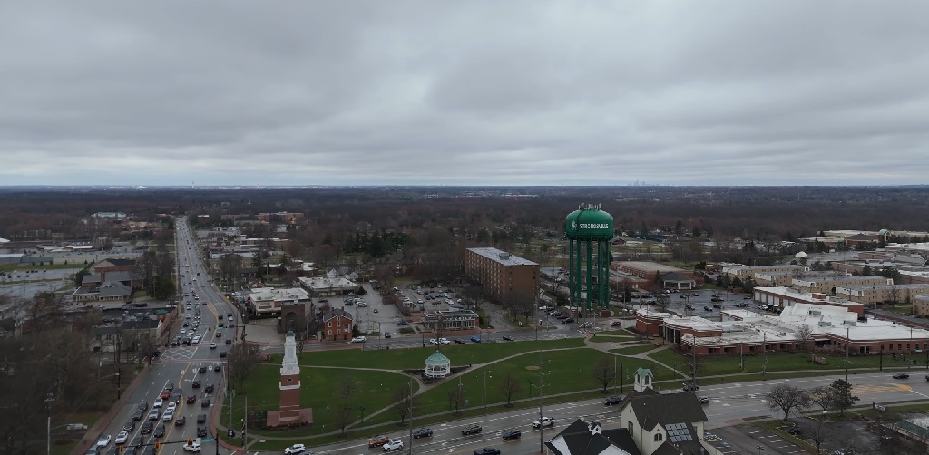 Aerial view of Strongsville, Ohio, featuring the city’s green water tower, busy roads, and a mix of residential and commercial areas under a cloudy sky
