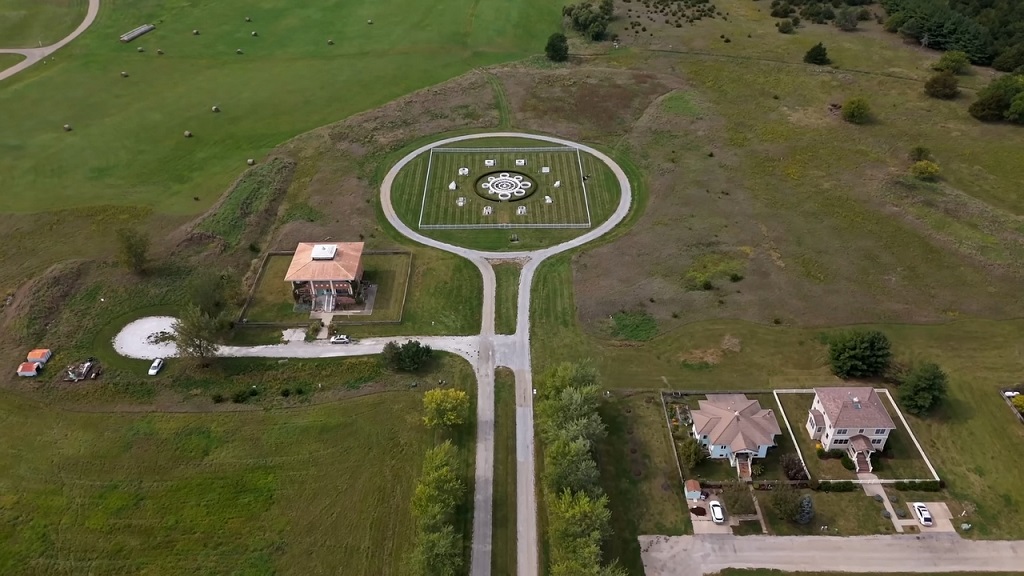 Aerial view of Maharishi Vedic City with a circular park, aligned roads, and east-facing houses surrounded by farmland