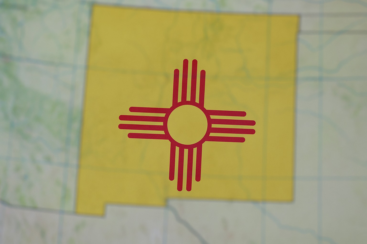 The flag of New Mexico state, with a map in the background.