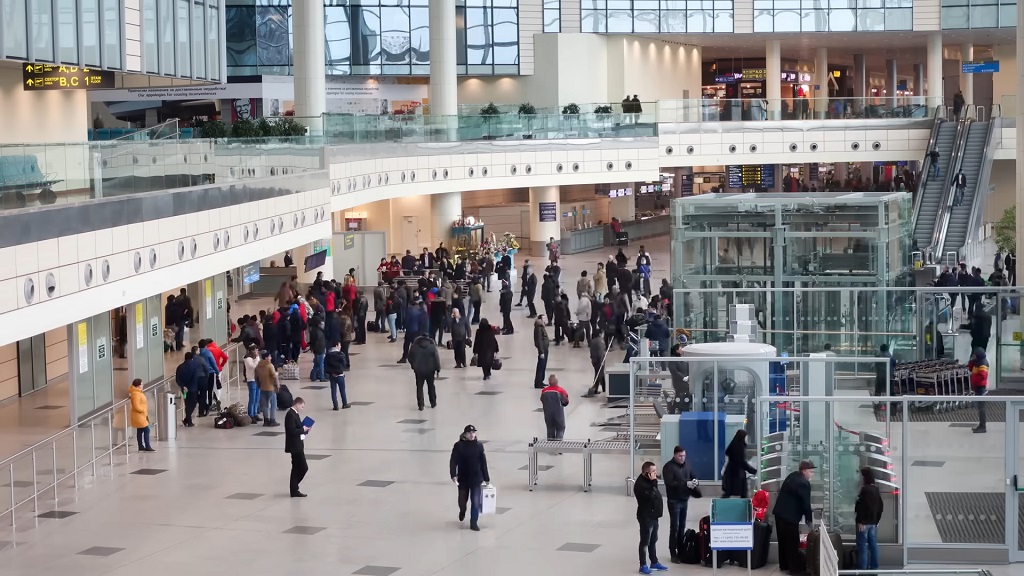 Wide interior view of Hartsfield-Jackson Atlanta International Airport with passengers moving through a large terminal concourse