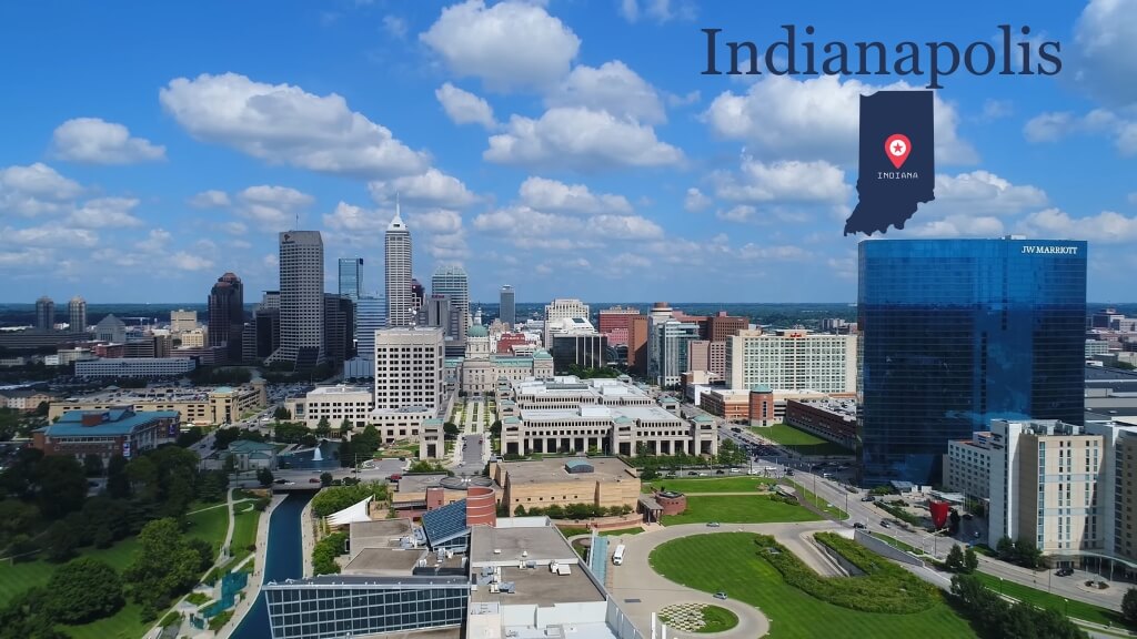 Aerial view of downtown Indianapolis featuring government buildings, green spaces, and a dense urban layout