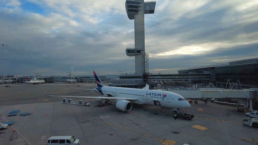 LATAM aircraft at a gate at John F. Kennedy International Airport with the control tower in view
