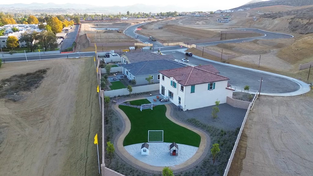 Aerial view of newly built suburban homes in a developing California neighborhood, surrounded by undeveloped land and ongoing construction, illustrating limited housing supply expansion