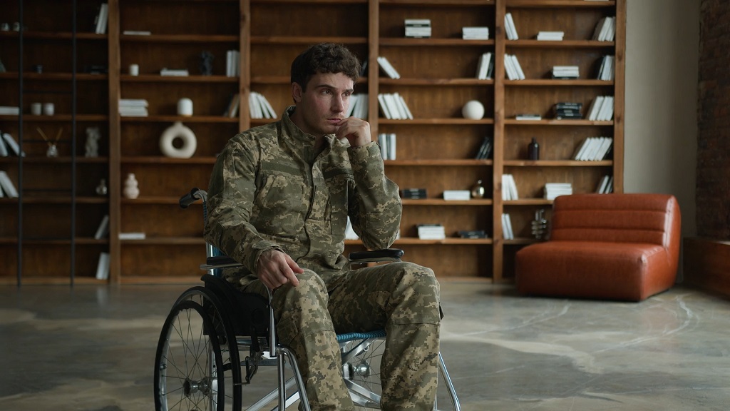Disabled veteran in a wheelchair wearing a military uniform indoors, representing financial relief and support programs for service-connected disabilities