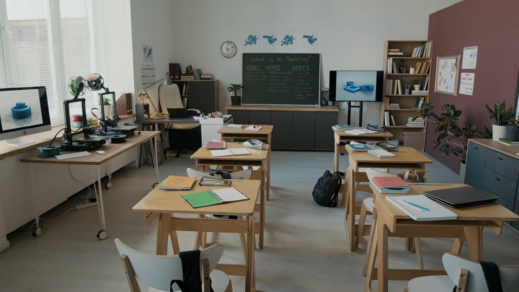 Empty modern classroom with desks, notebooks, and educational technology equipment