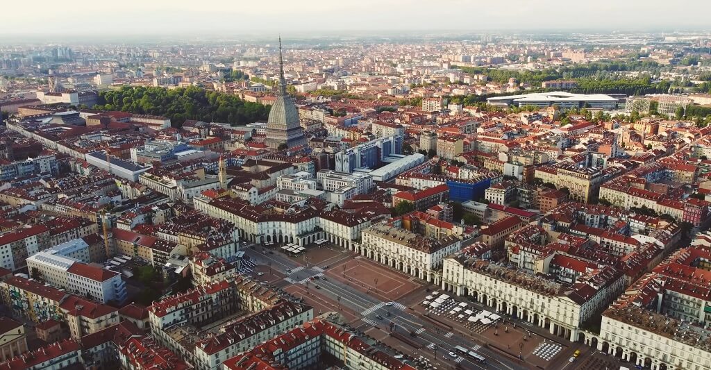 Aerial view of Turin, Italy, featuring Piazza Castello and the Mole Antonelliana surrounded by historic city buildings