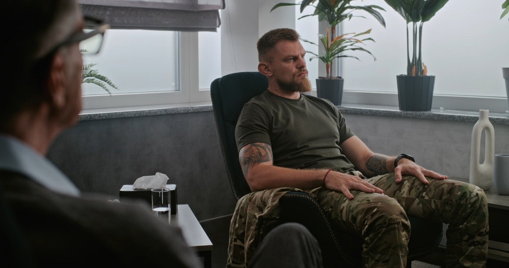 Veteran seated in a counseling office during a medical or mental health appointment, representing access to VA health care services